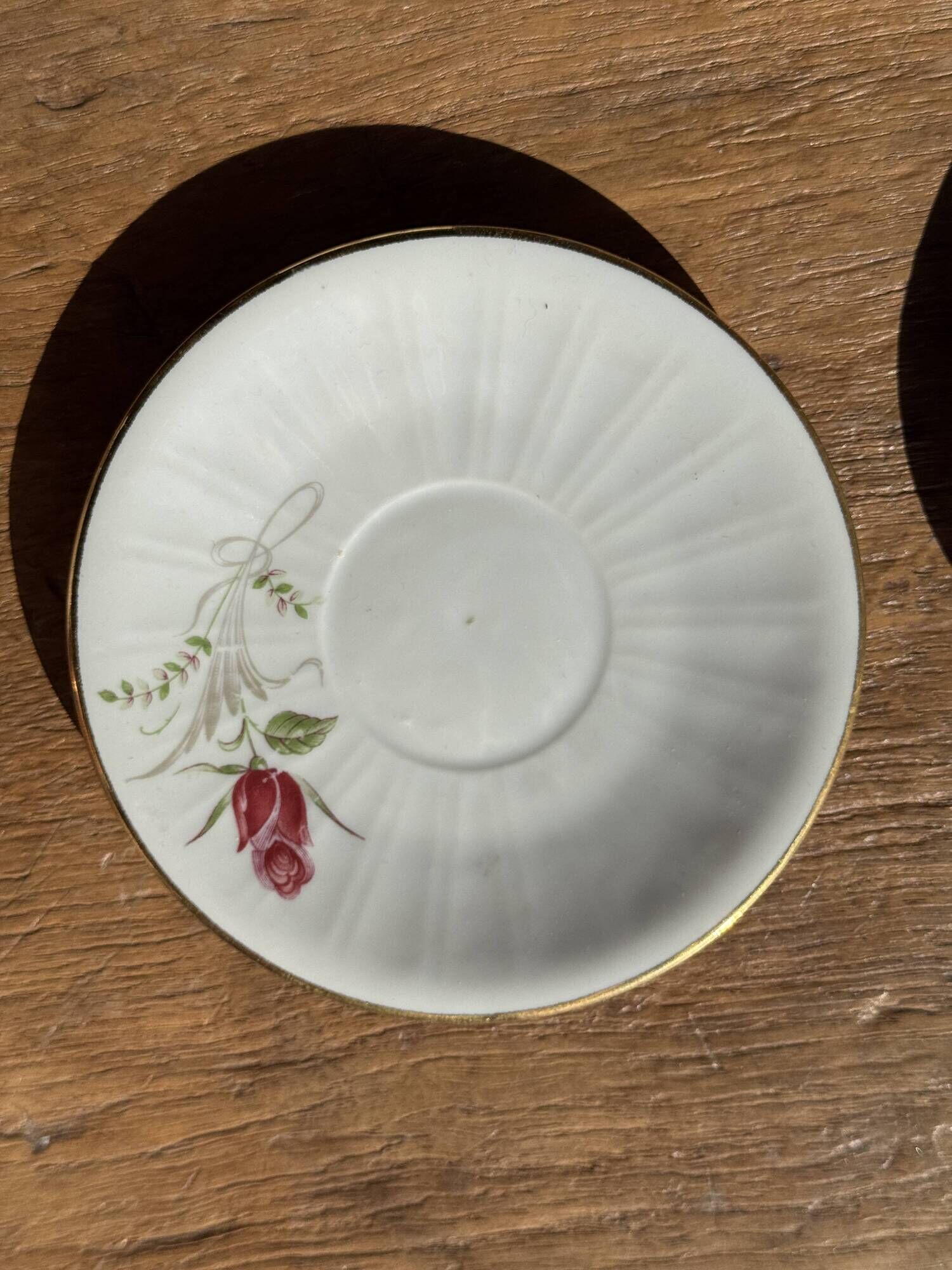 Pair of white porcelain cups from ADP France with a floral pattern and their s