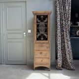 Column storage unit with a sculpted metal door.