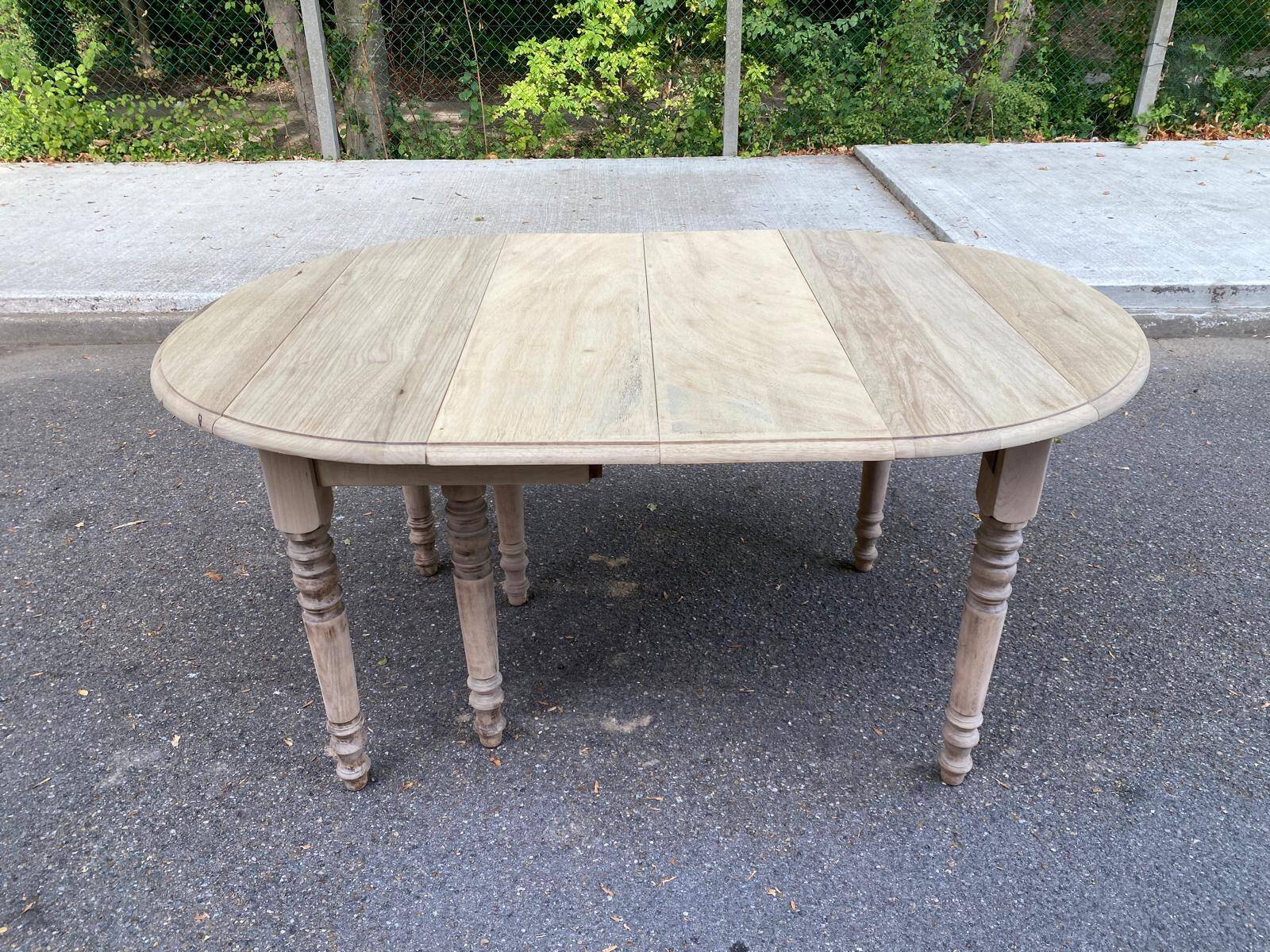 Round extendable dining table with flaps, stripped in raw oak, with 3 extensions.