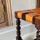 Antique turned wooden stool with woven leather.