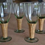 Four stemmed glasses surrounded by rattan.