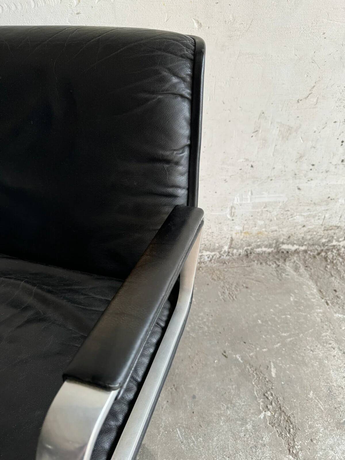 Wilkhahn Delta lounge chair in black leather with polished aluminum base and footrest (1970s)