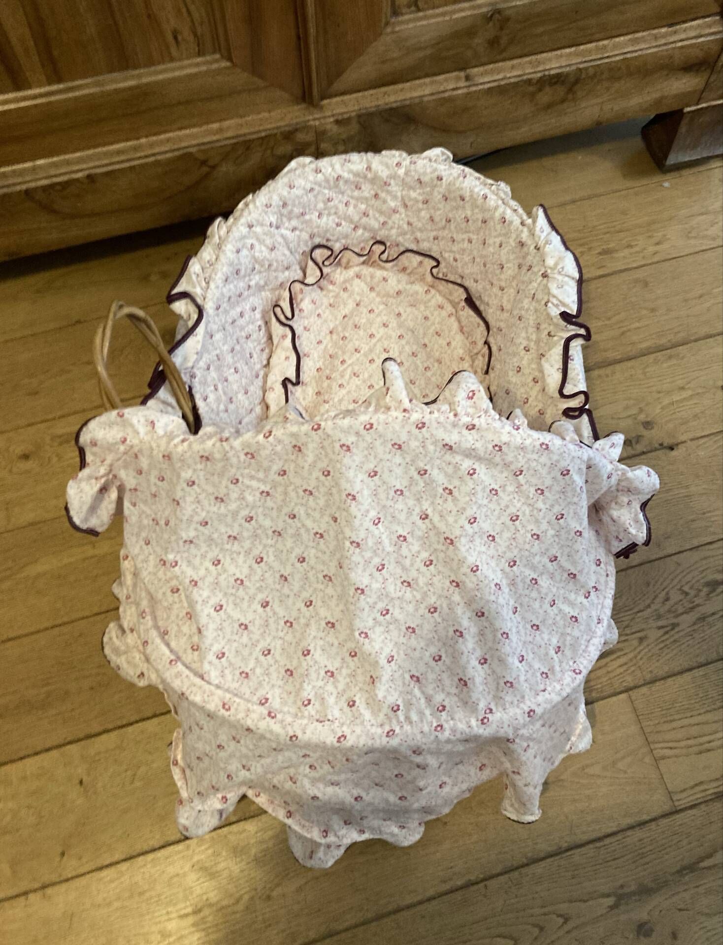 1960s wicker cradle with mattress and drapes.