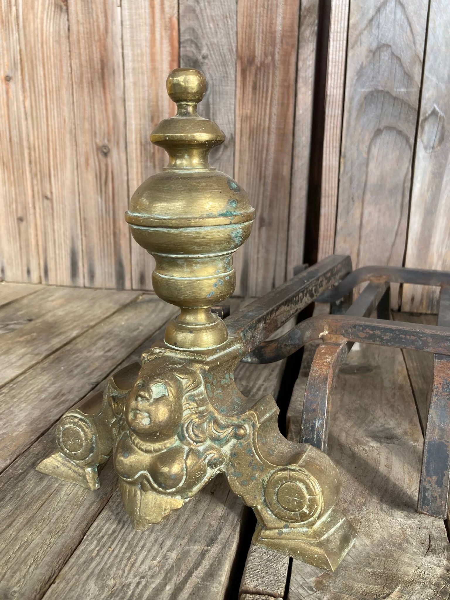 Pair of andirons and grates in cast iron and bronze with gilded grotesques, 17th century