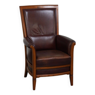 Very comfortable classic cowhide armchair with a high back in a mild Art Deco style