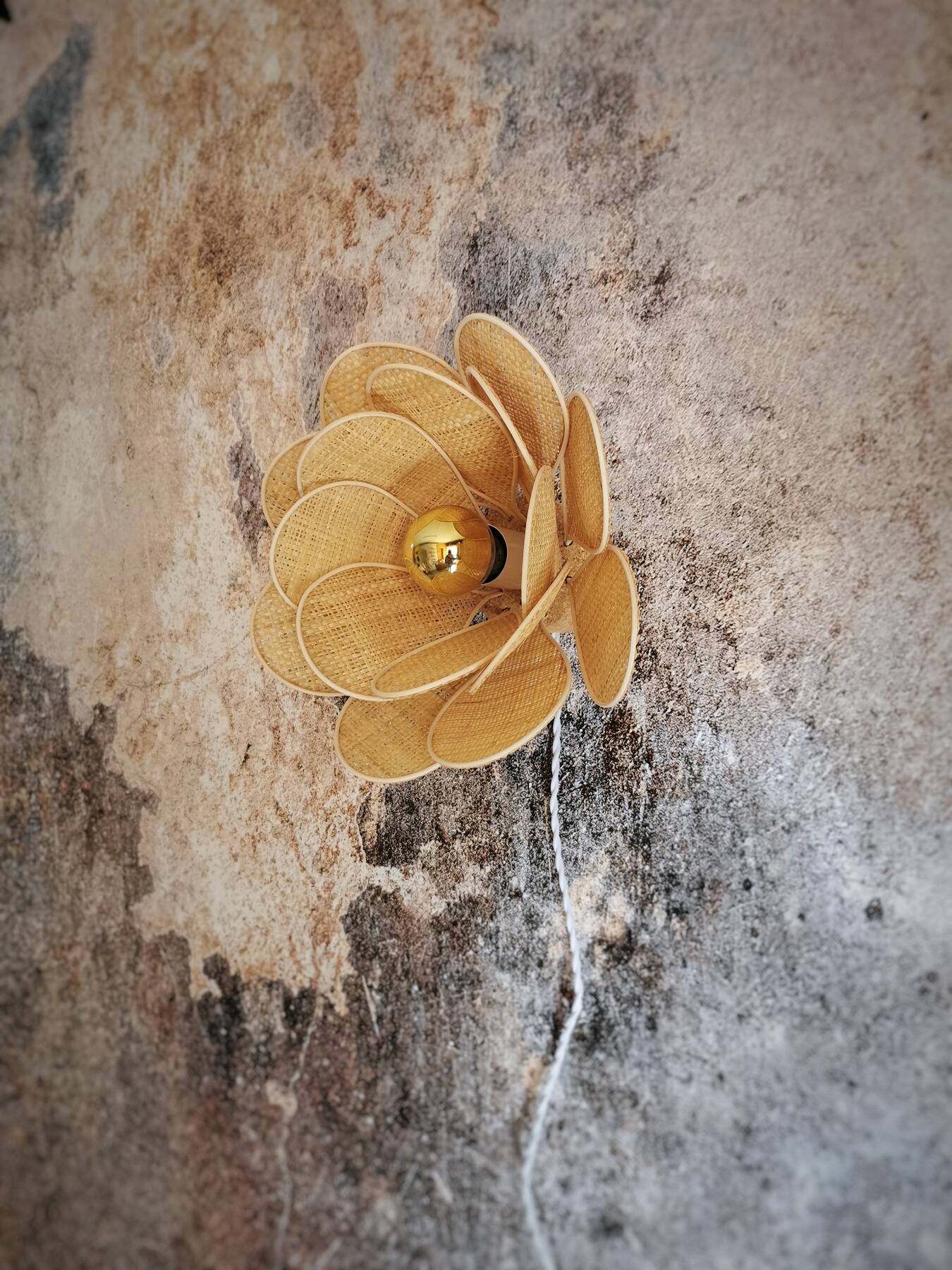 Flower wall light made of rattan and raffia petals