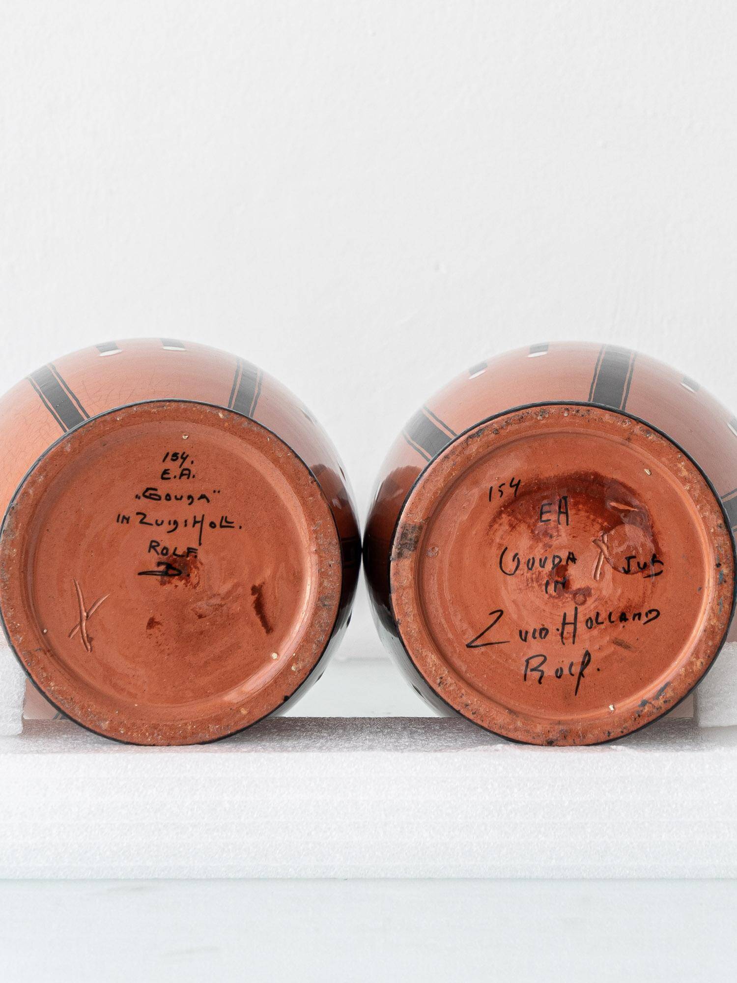 Pair of Dutch Art Deco vases, hand-painted Gouda-style ceramic with bold glazing.