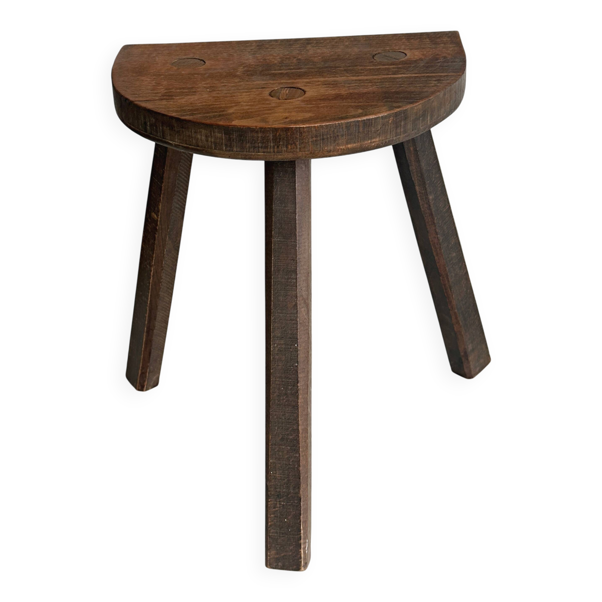 Antique wooden tripod stool with a semi-circular seat.