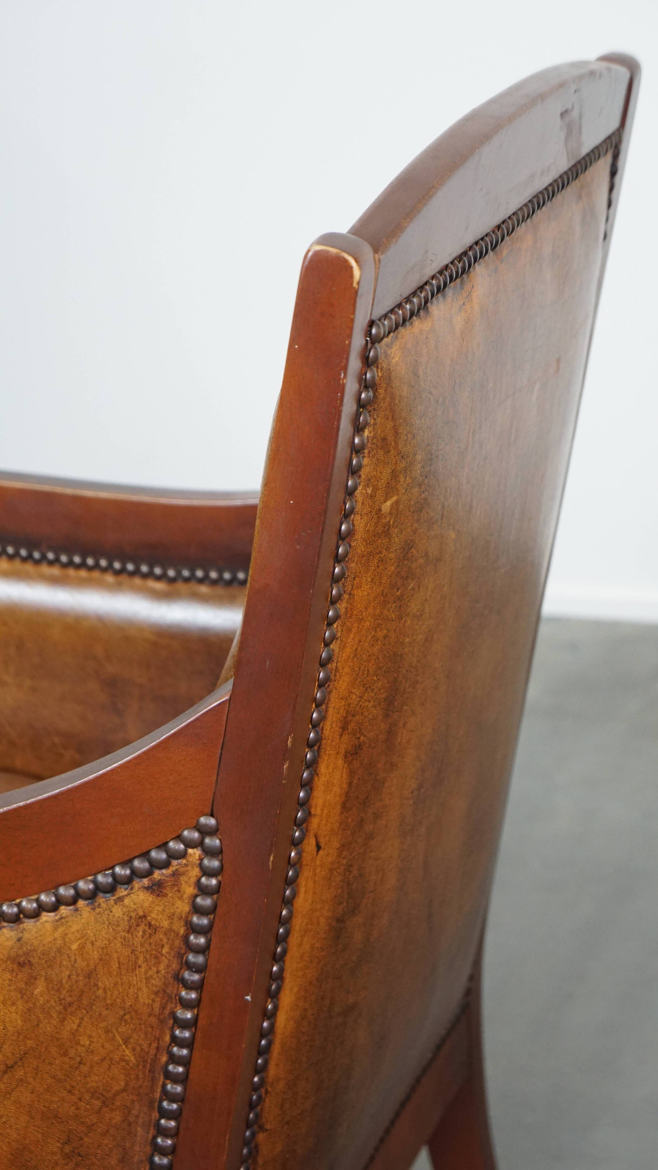 Sheepskin and wooden vintage Art Deco design armchair in a cognac color