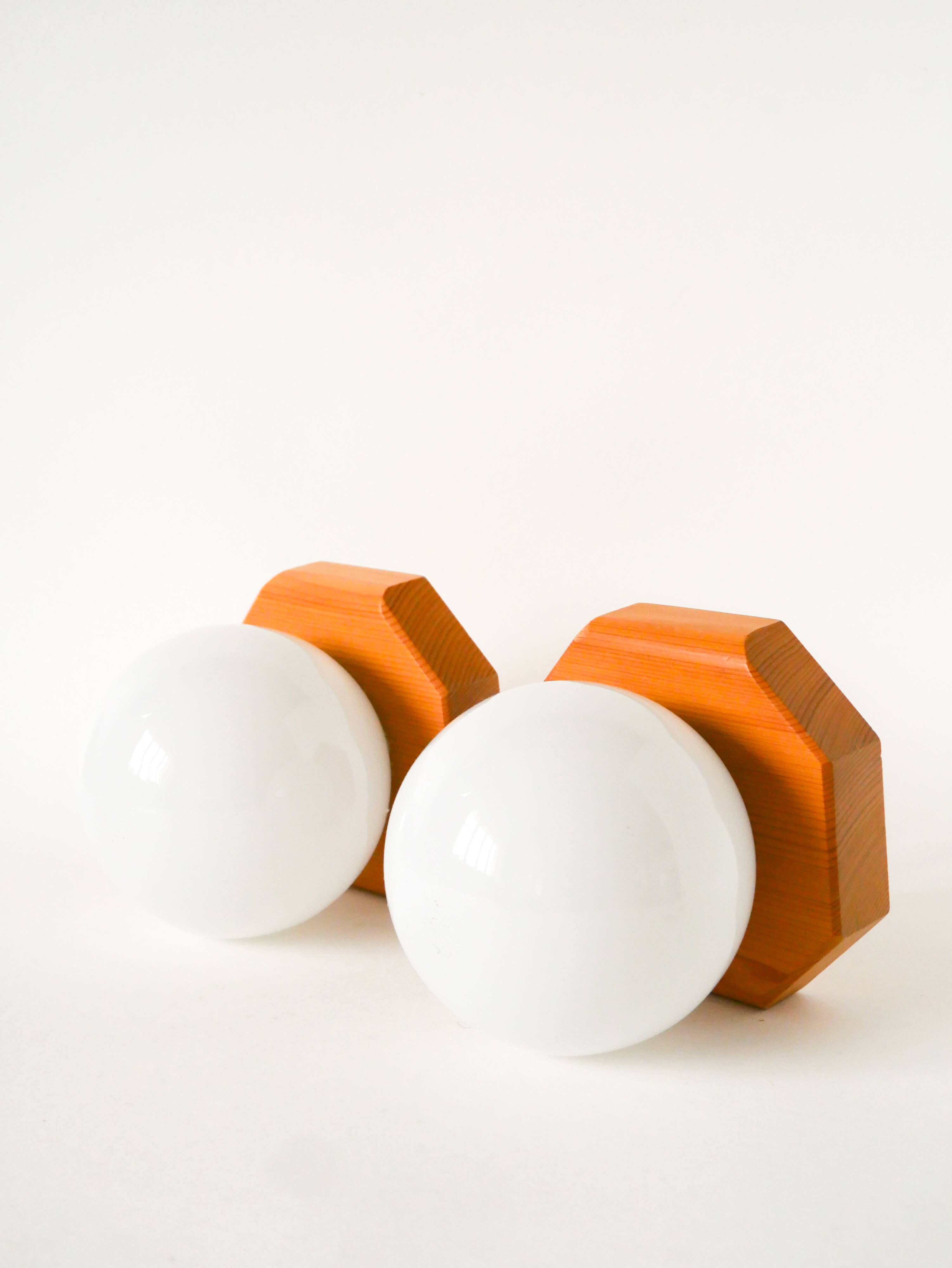 Pair of globe wall lights in opaline with a pine base, 1980.