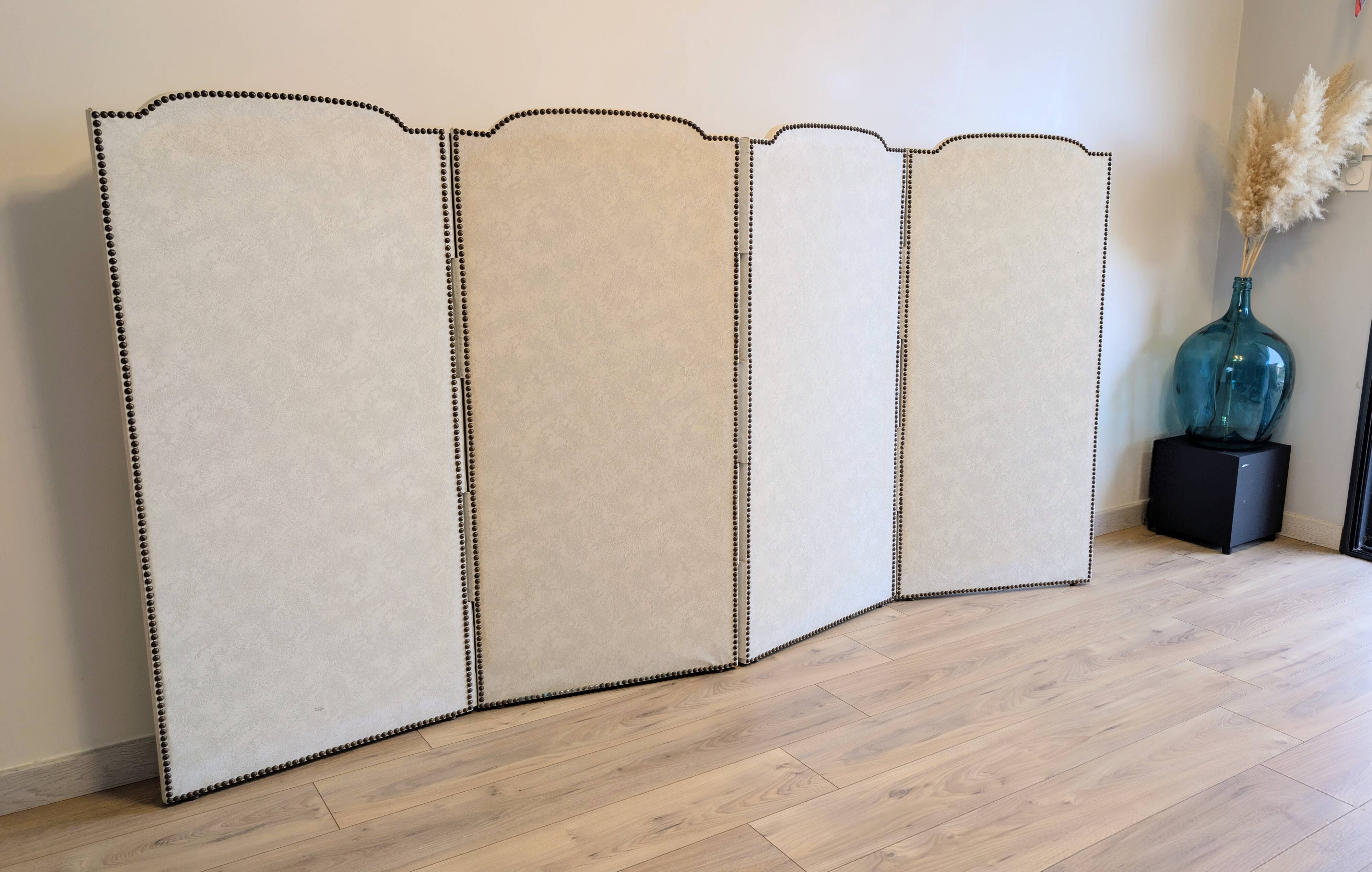 Vintage white faux leather screen with four studded panels, elegant decor.