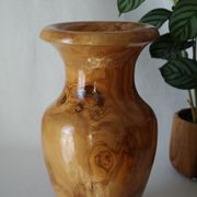 Artisanal turned olive wood vase with varnish.