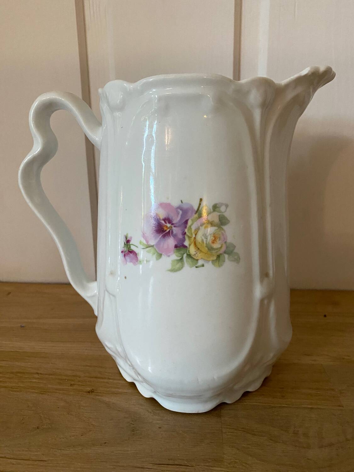 Old ceramic pitcher decorated with flowers