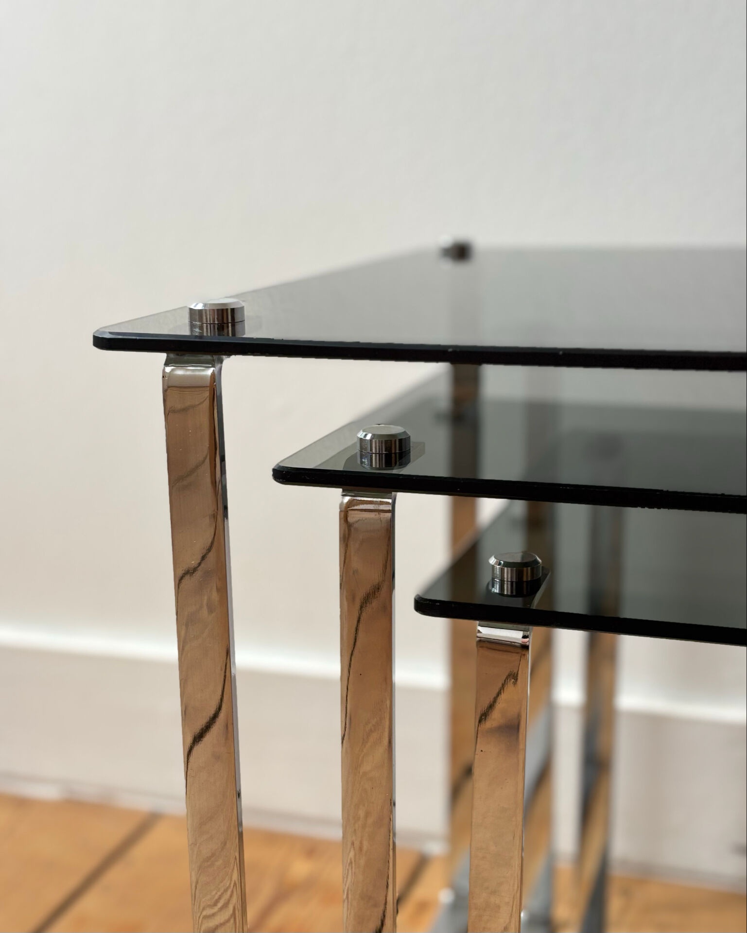 Nest of coffee tables in chrome with smoked glass top.