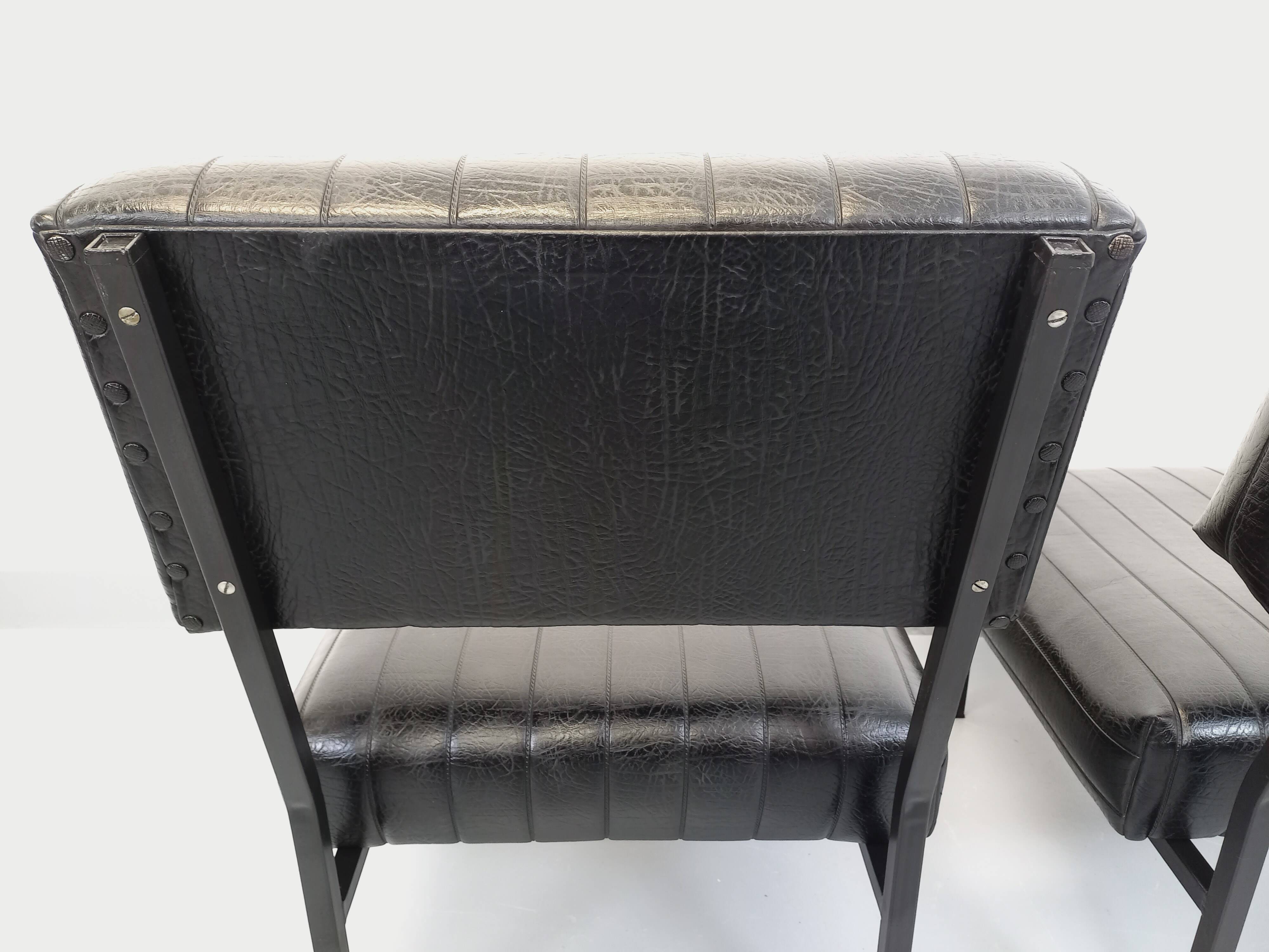 Set of 2 vintage modernist armchairs in black faux leather and metal.