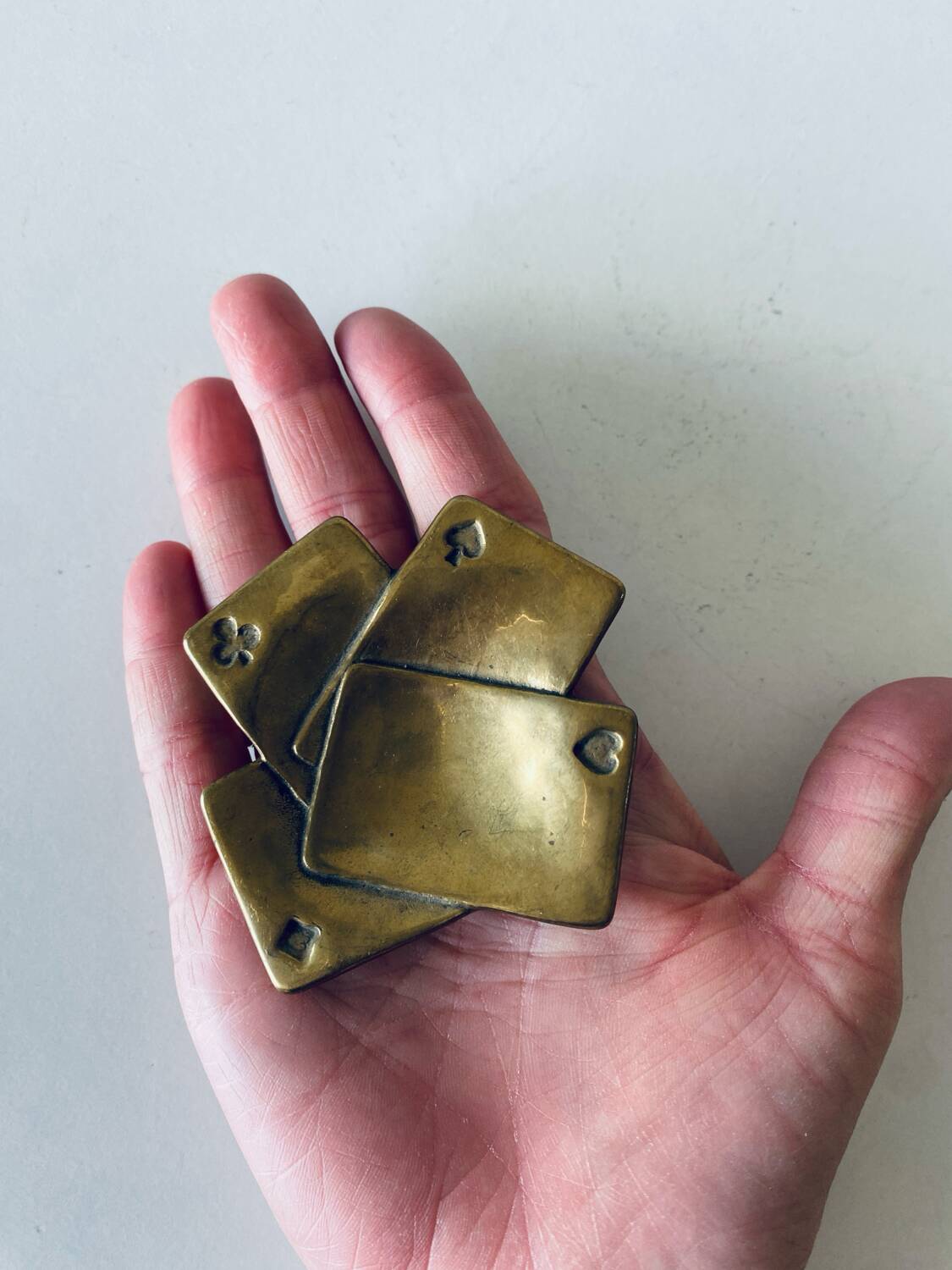 Empty pocket square of aces in brass