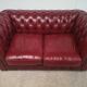 Red two-seater chesterfield sofa