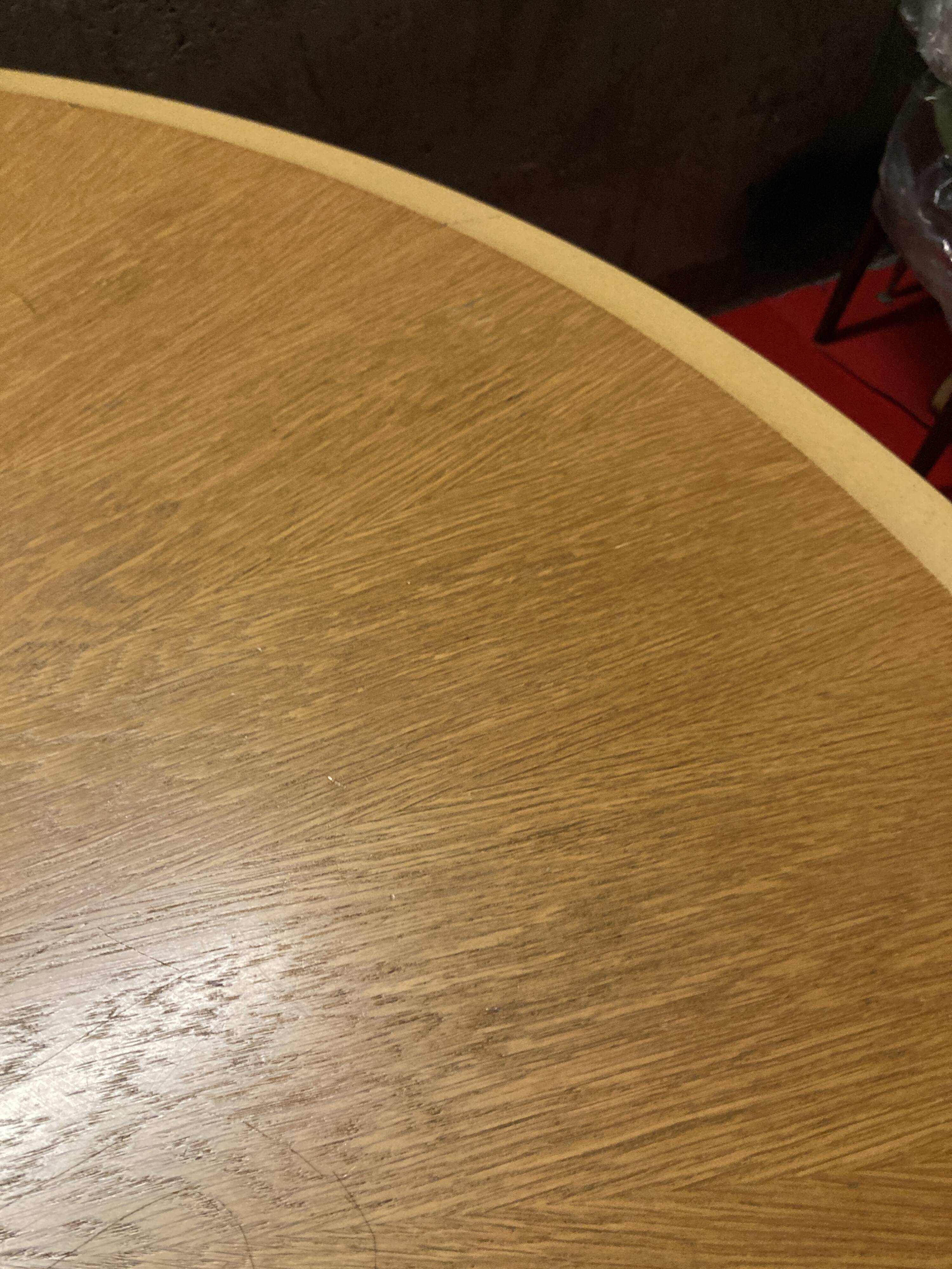 Round wooden and metal quadripod dining table