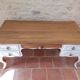 Solid wood desk with distressed white paint.