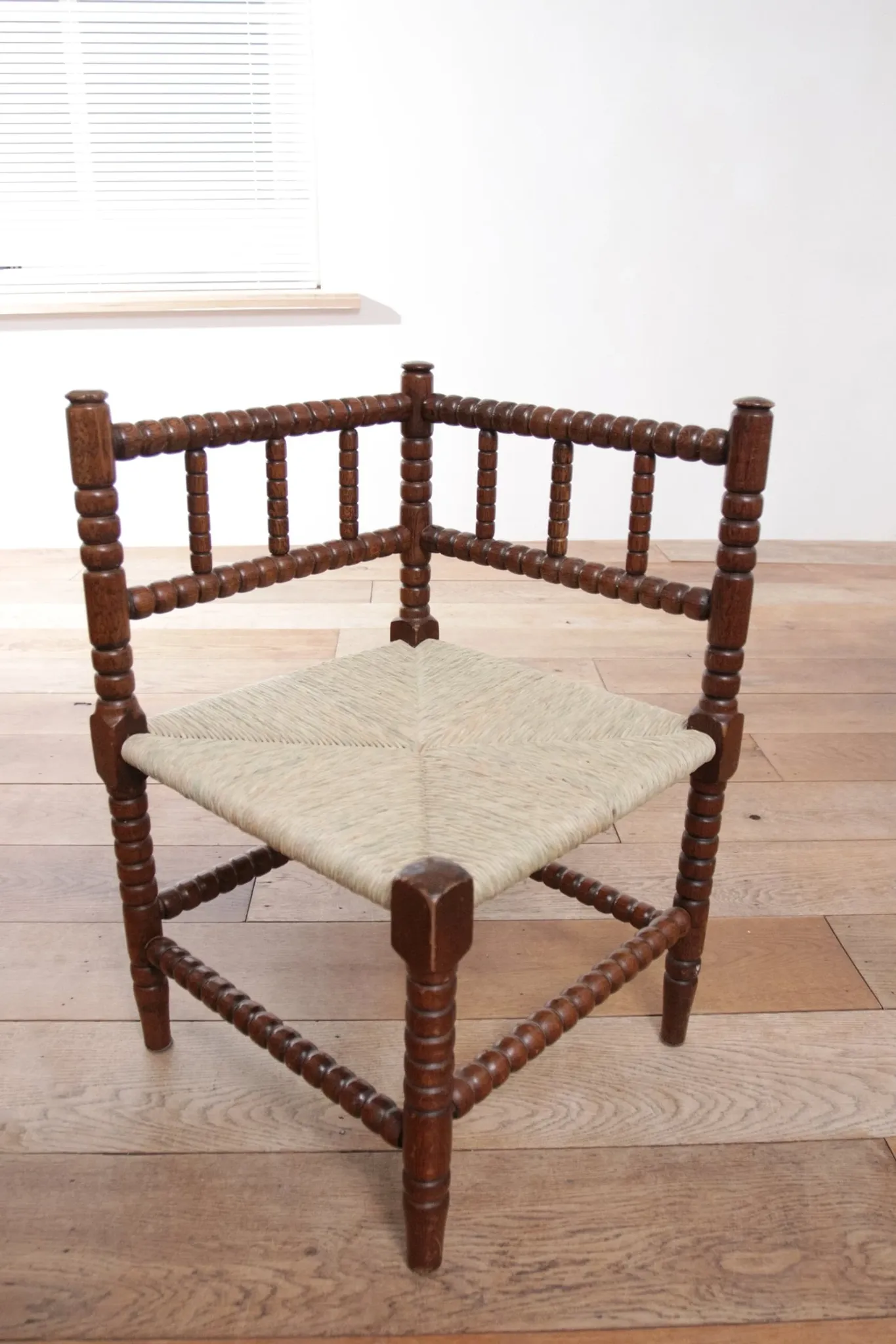 Antique Dutch oak corner chair with turned spindles and new rush seat