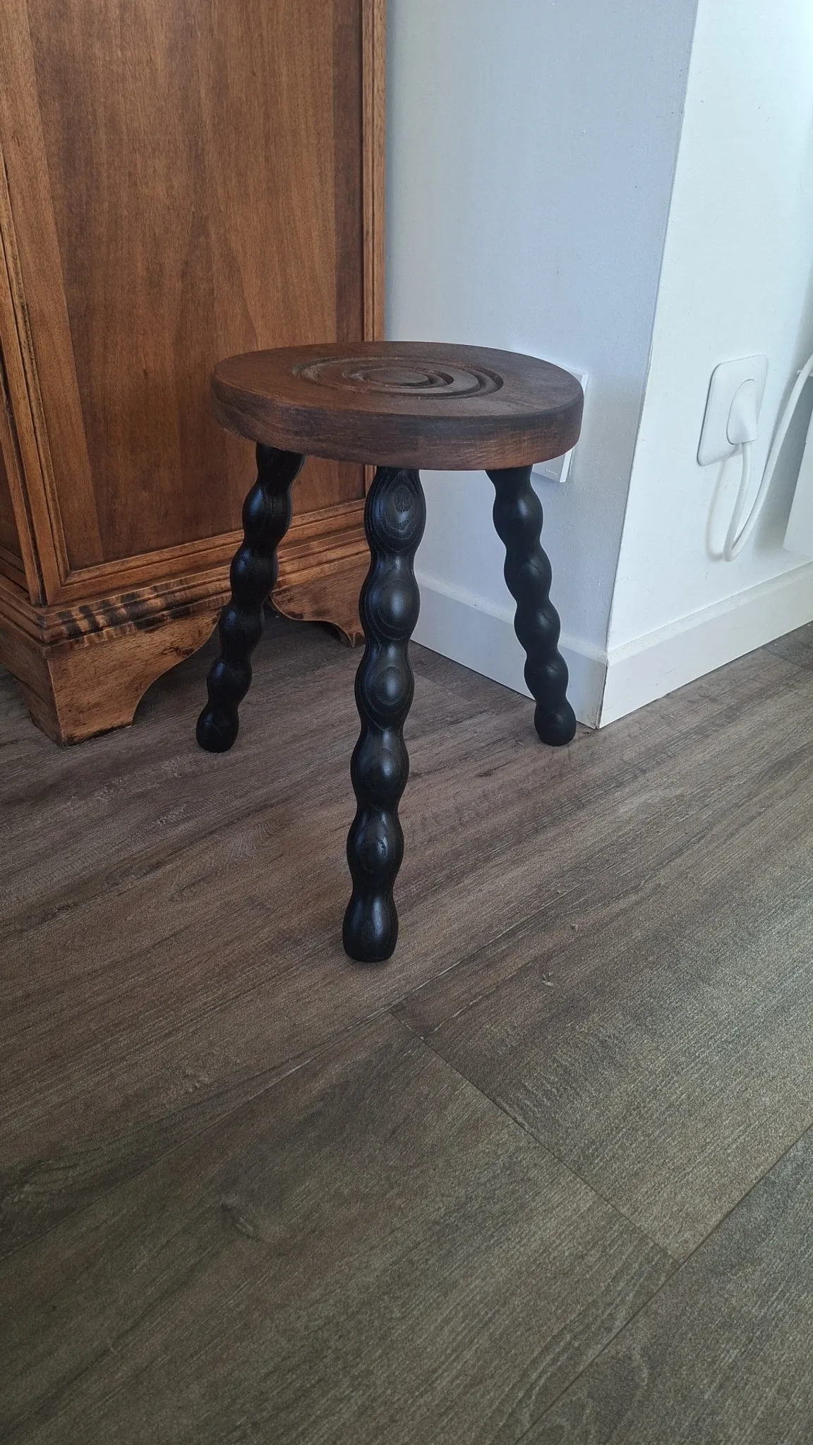 Brown and black wooden tripod stool