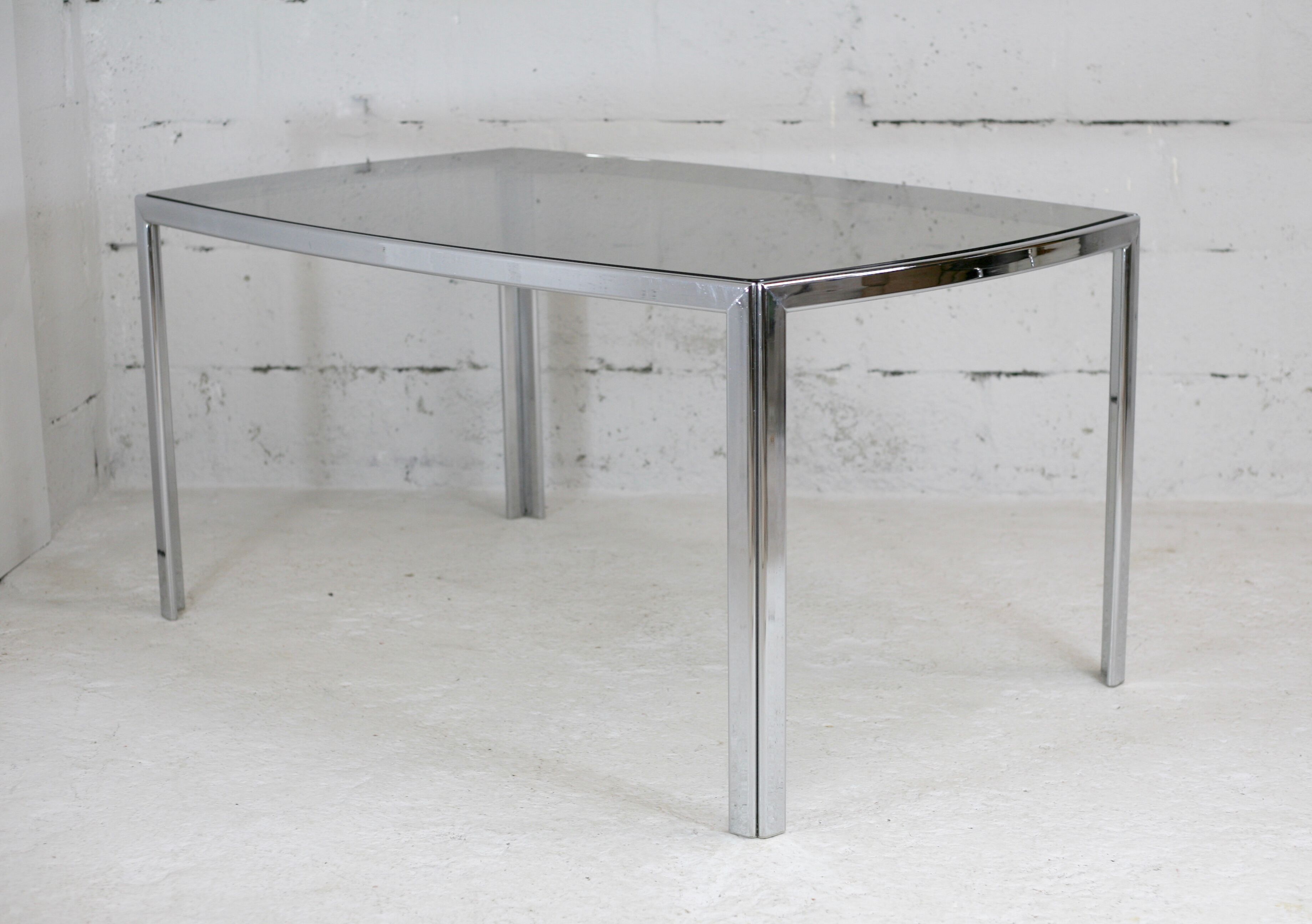 Living table. chrome metal, curved smoked glass slab, france, circa 1970.
