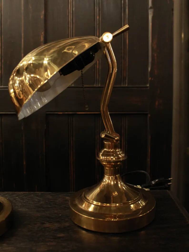 Pair of articulated brass lamps in the shape of a shell.