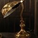 Pair of articulated brass lamps in the shape of a shell.
