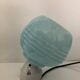 Wall light in ceramic with a light blue glass globe.