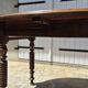 Round dining table with a drop-leaf top in solid walnut, late 19th century.