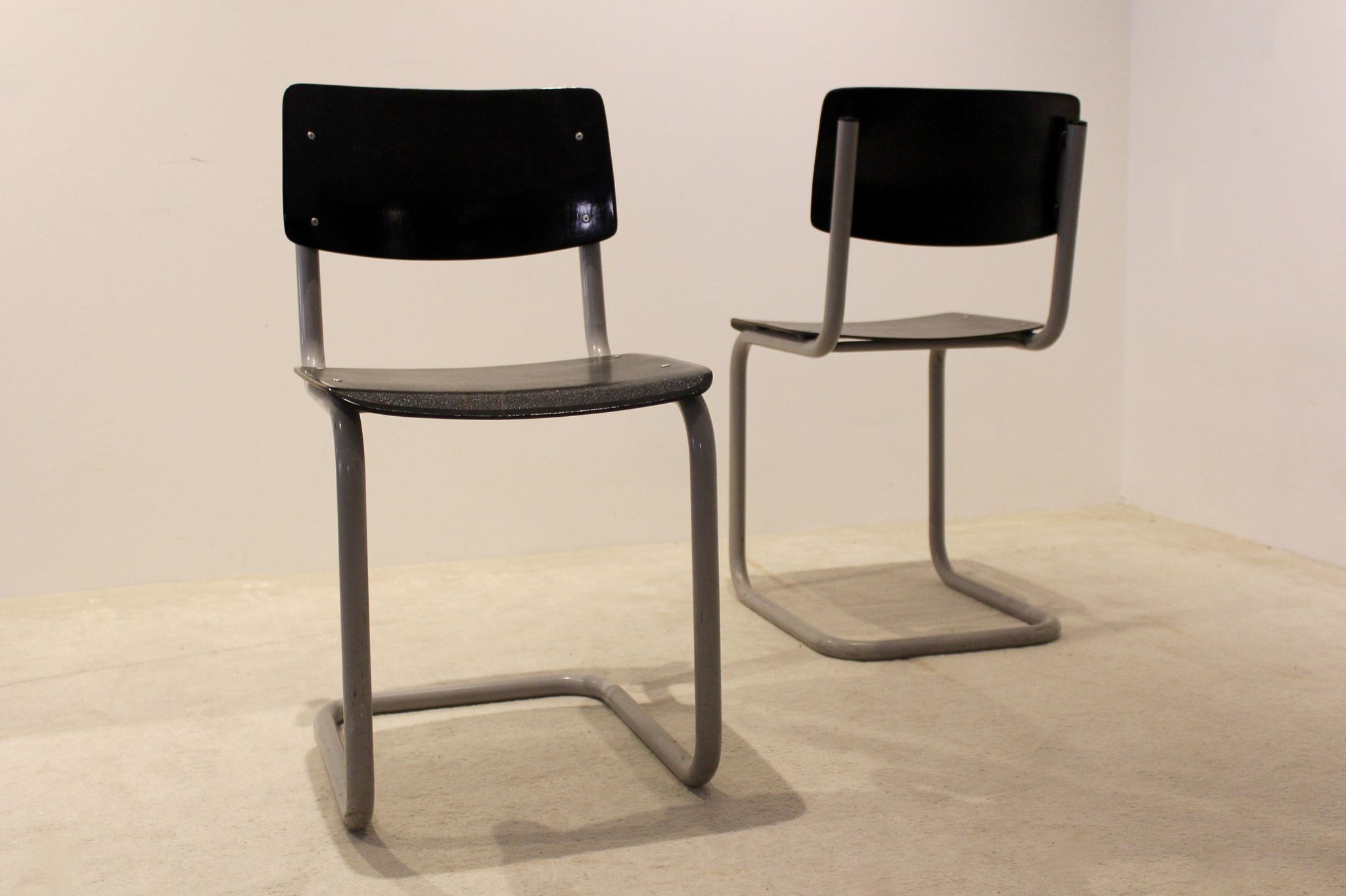 Ensemble de six chaises industrielles en contreplaqué Gispen dans un cadre gris et wengé.