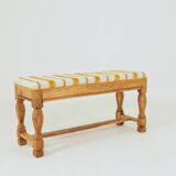 Vintage oak bench with striped linen fabric in a country style.