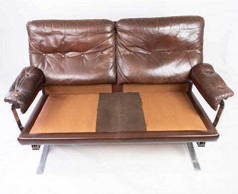 Two seater sofa upholstered with patinated brown leather and frame in metal, designed by Arne Norell