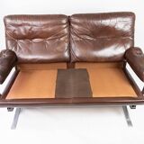 Two seater sofa upholstered with patinated brown leather and frame in metal, designed by Arne Norell