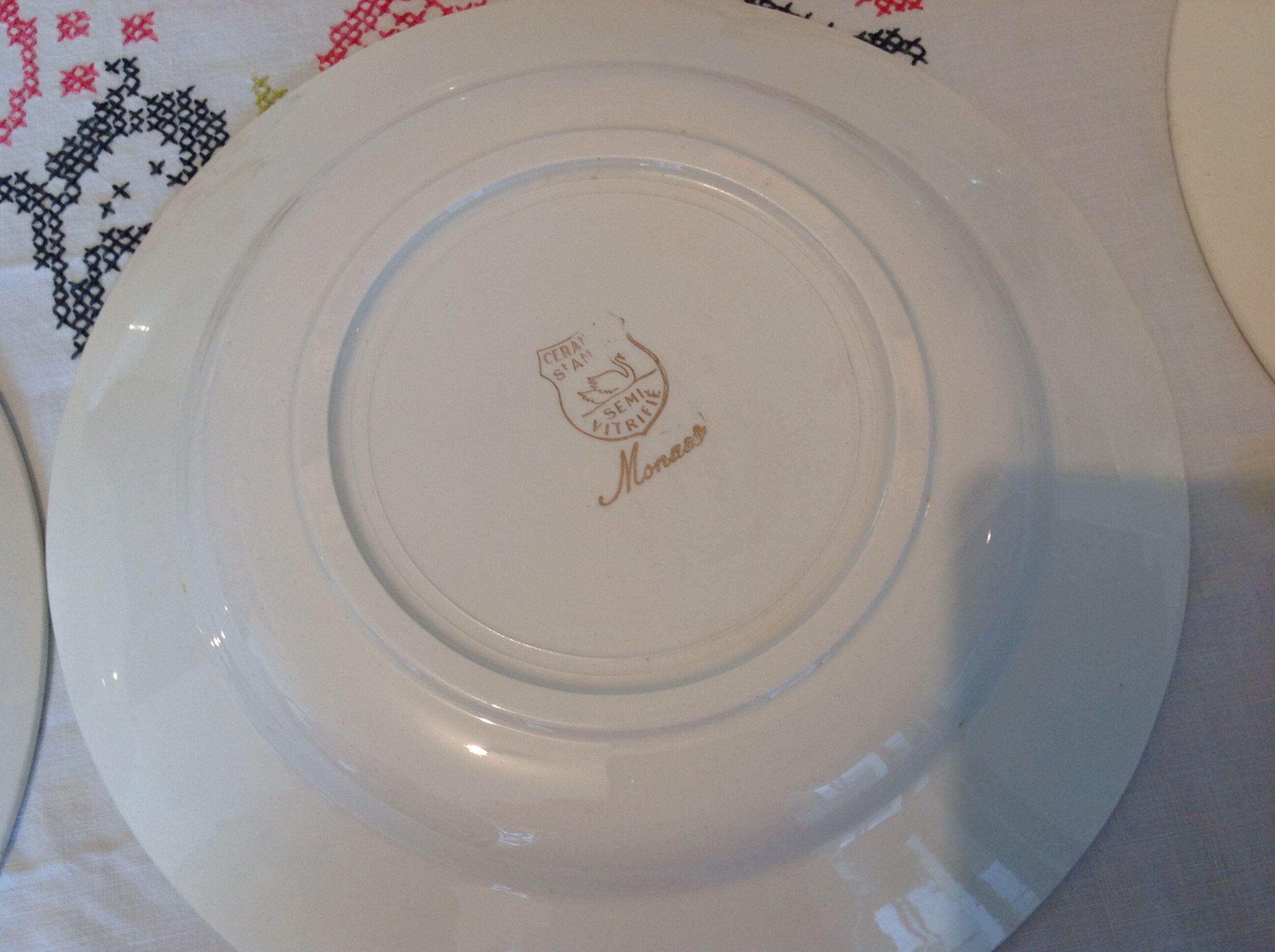 Six white hollow plates on board yellow Monaco 60