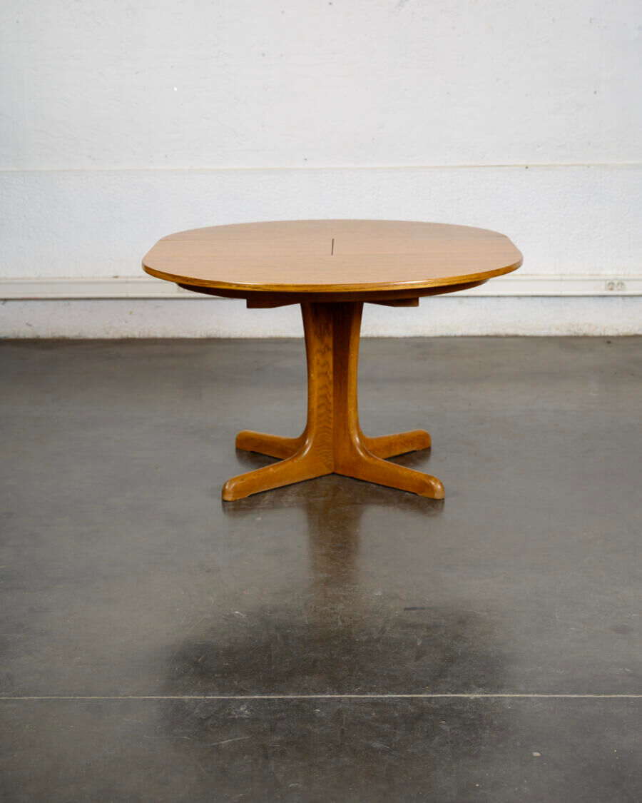 Round teak table with an extension.