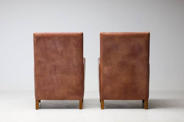 Pair of Art Deco armchairs in brown leather and teak, Netherlands, 1970s.