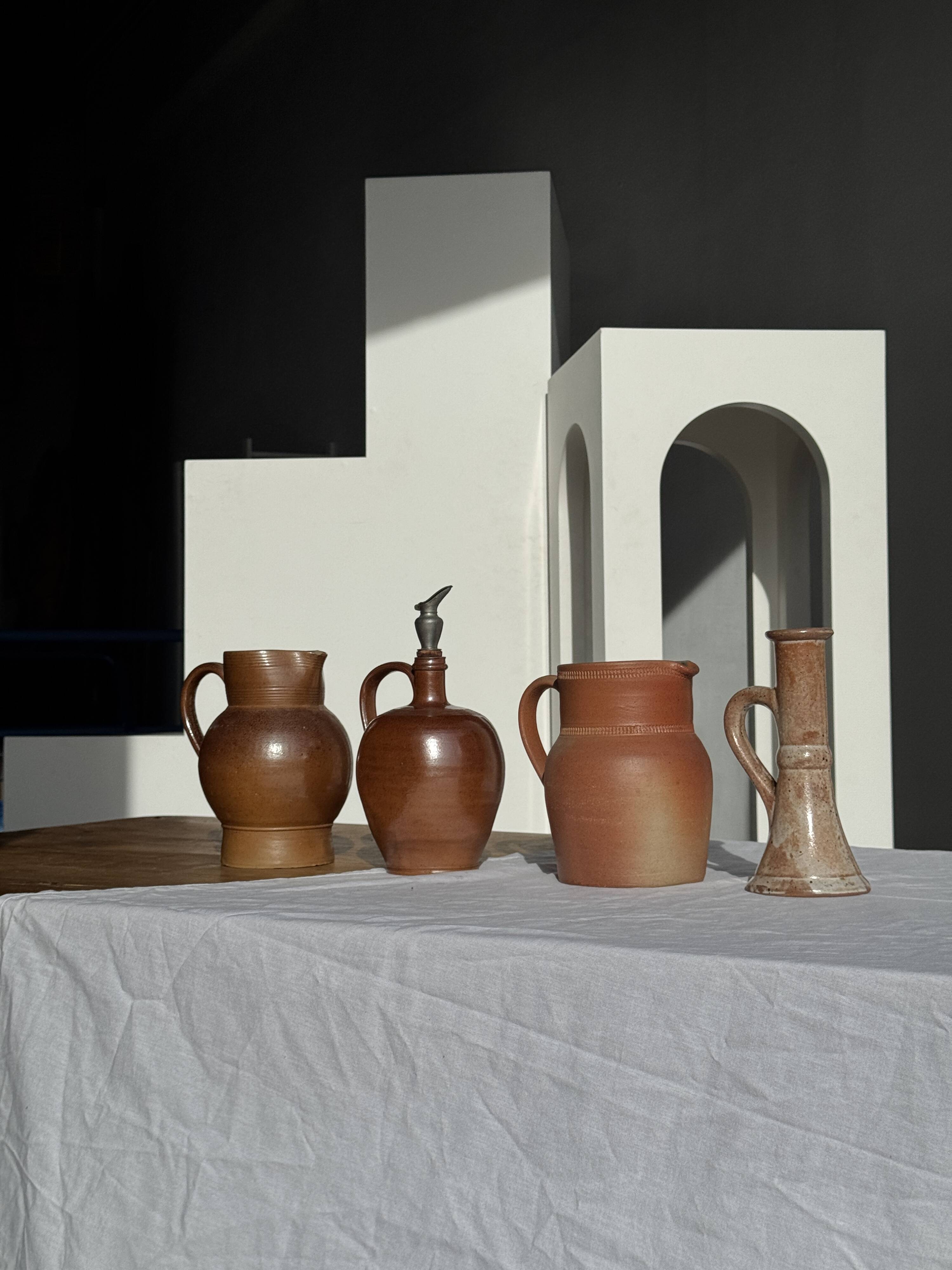 Ancient stoneware jug with a pewter spout.