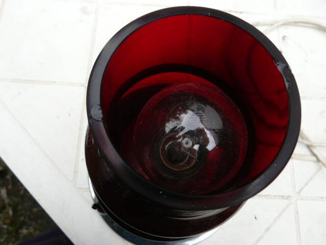 Red glass table lamp on a chrome base.