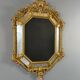 Antique octagonal mirror in richly carved gilded wood, Louis XV style.