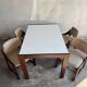 Mid-century white laminate dining table with dark wood base and 4 beige upholstered chairs