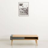 Table basse avec un caisson en chêne équipé de 2 portes coulissantes, pieds en chêne massif
