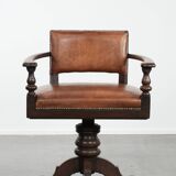 Elegant antique sheepskin leather desk chair with a heavy wooden frame