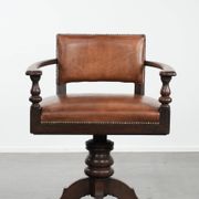 Elegant antique sheepskin leather desk chair with a heavy wooden frame