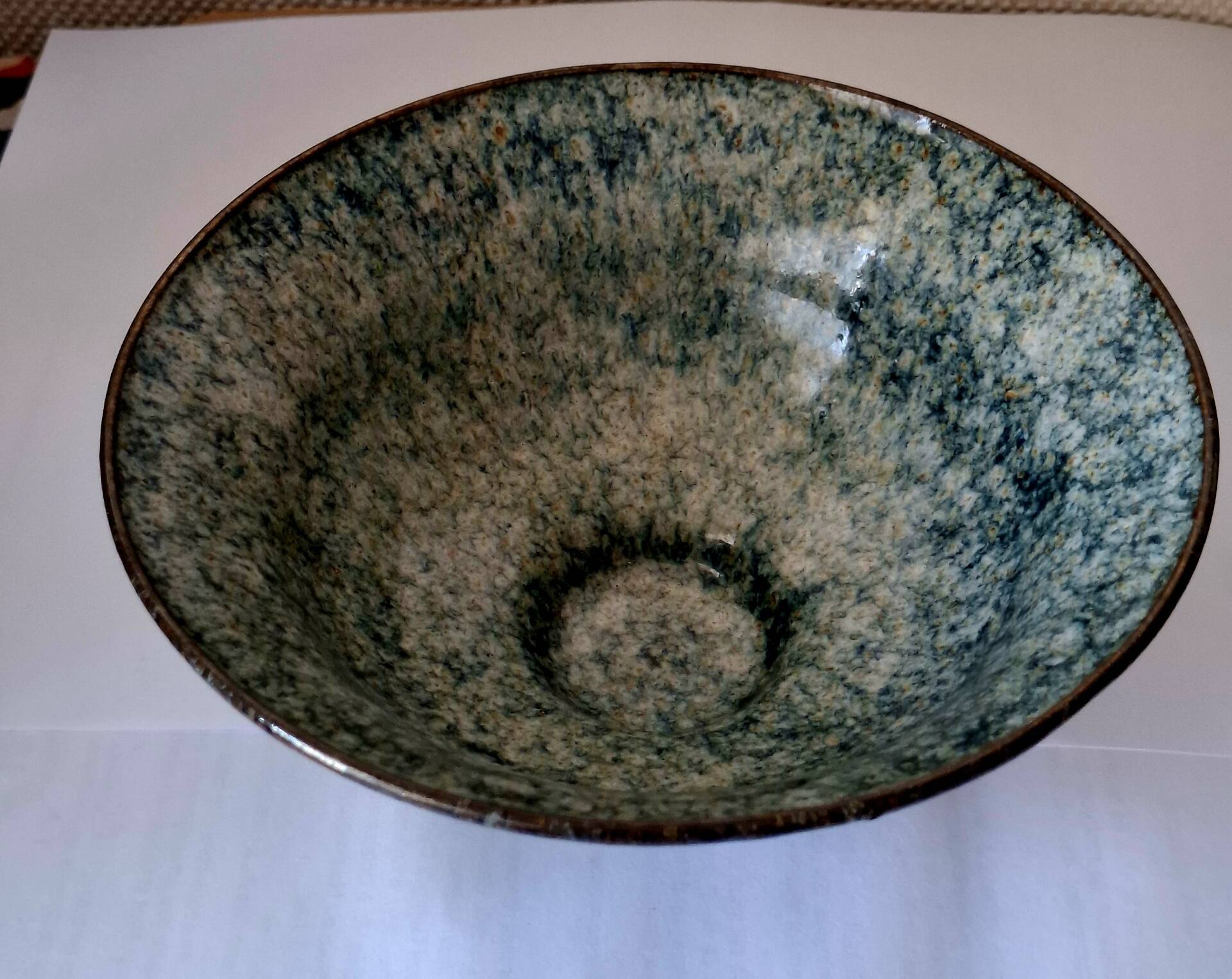 Bowl on a circular base or small blue ceramic dish.