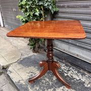 19th-century solid mahogany table with a tilting top and brass mechanism.
