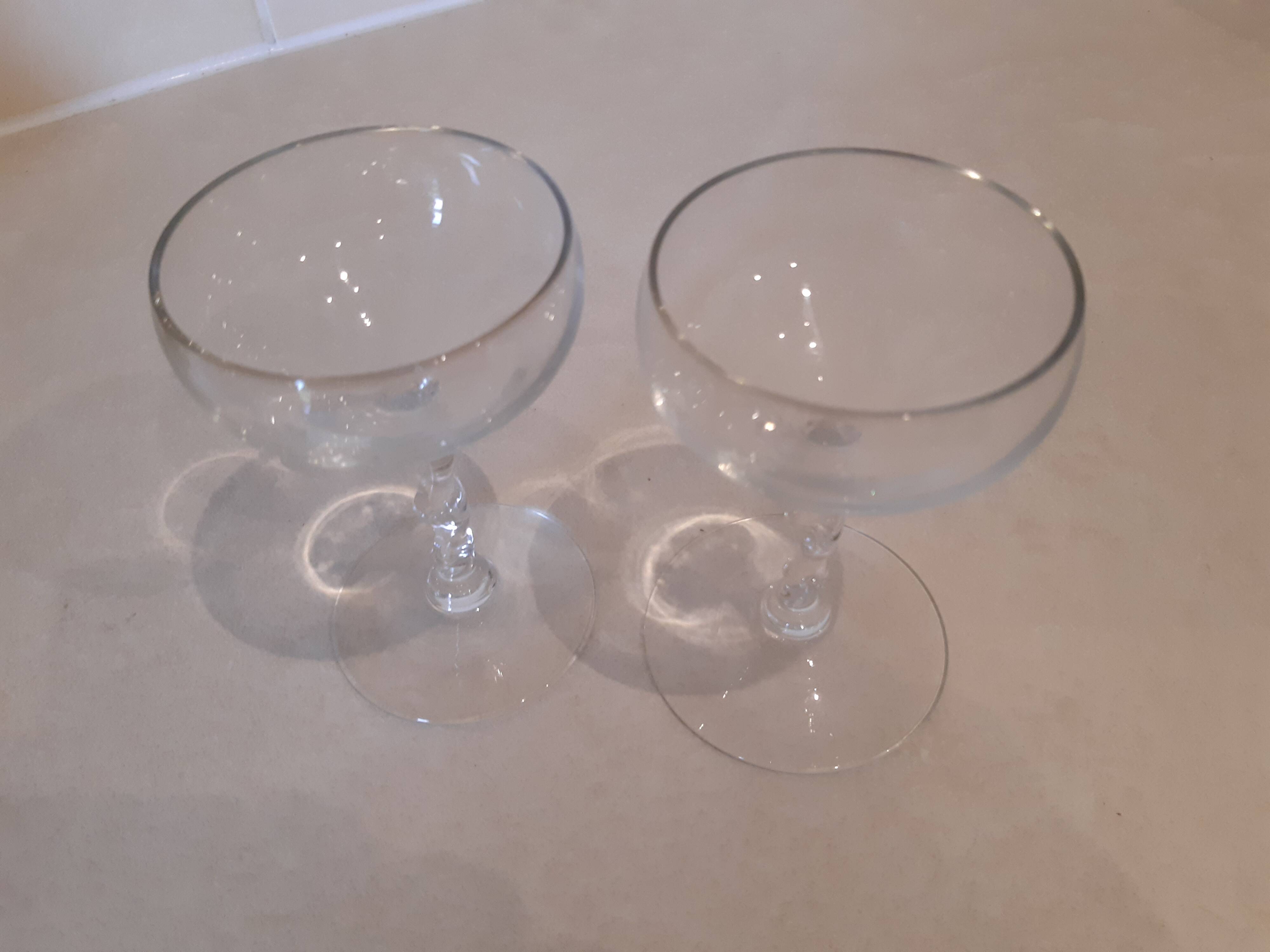 Two small crystal champagne glasses with twisted stems.