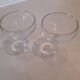 Two small crystal champagne glasses with twisted stems.