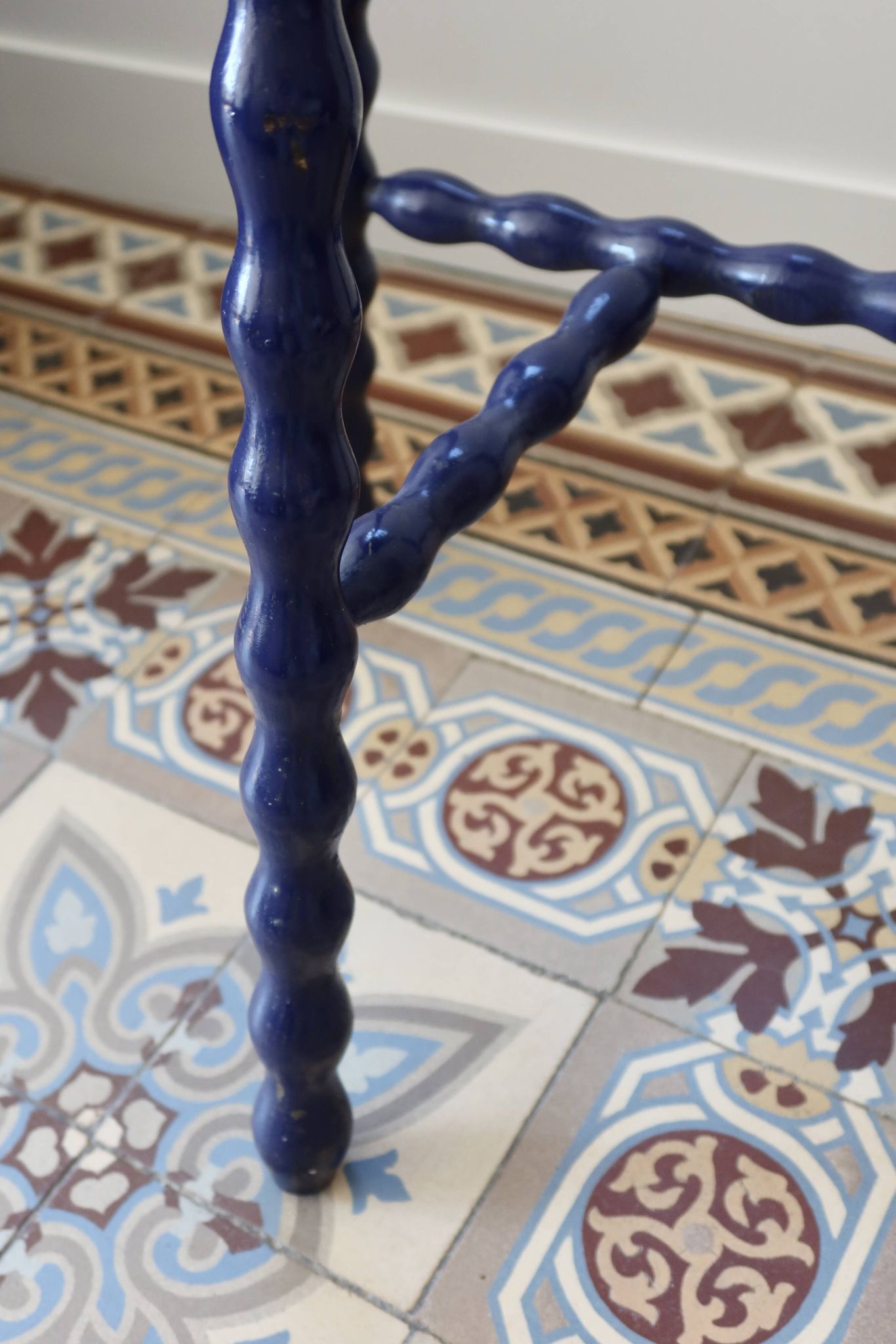 Vintage tripod stool made of turned wood, painted blue.