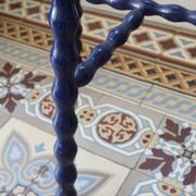 Vintage tripod stool made of turned wood, painted blue.